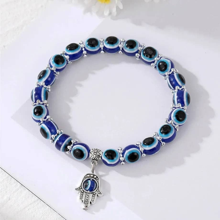 Blue evil eye beads bracelet with Hamsa hand charm on display
