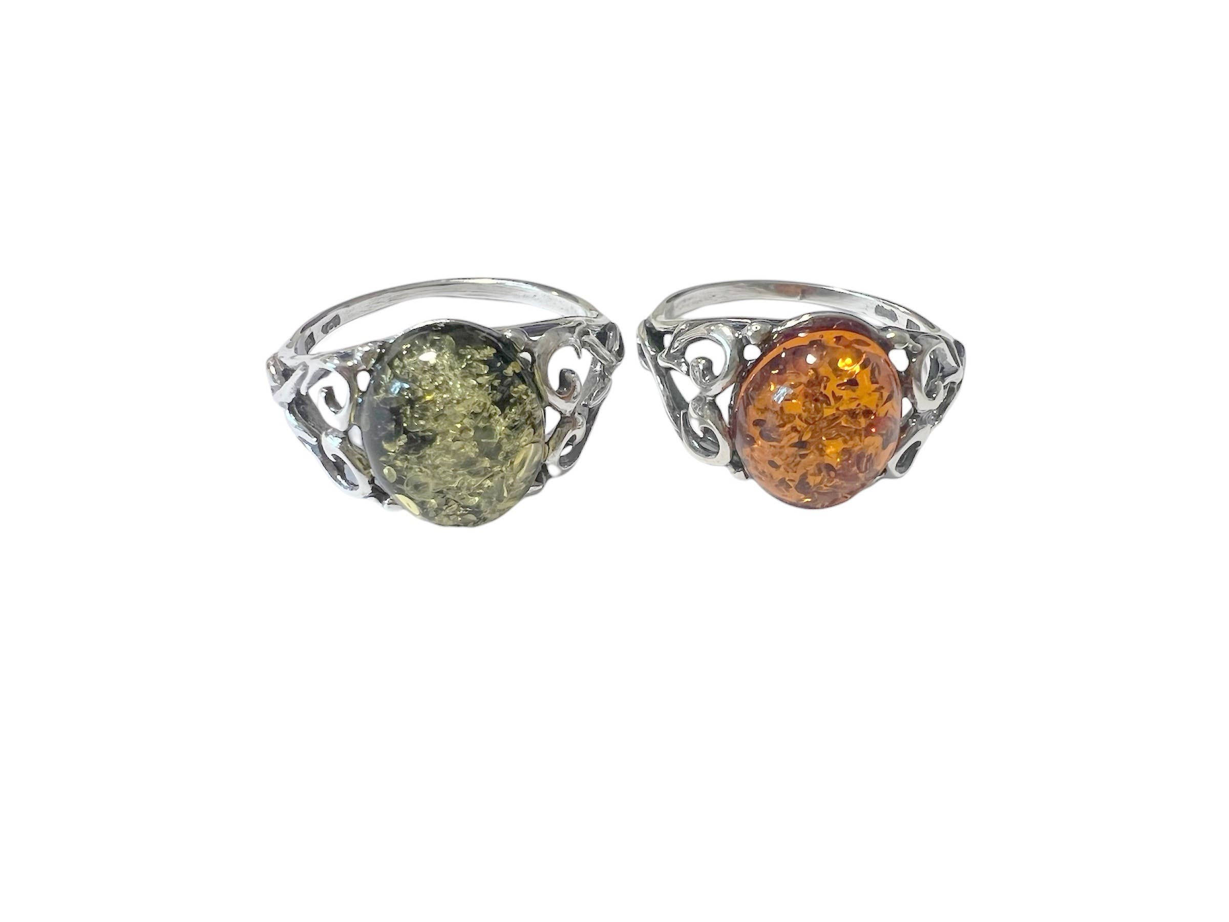 Two amber rings, green and orange stones, intricate silver filigree settings.