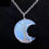Thumbnail: Silver chain necklace with moon pendant and tree design on black background.