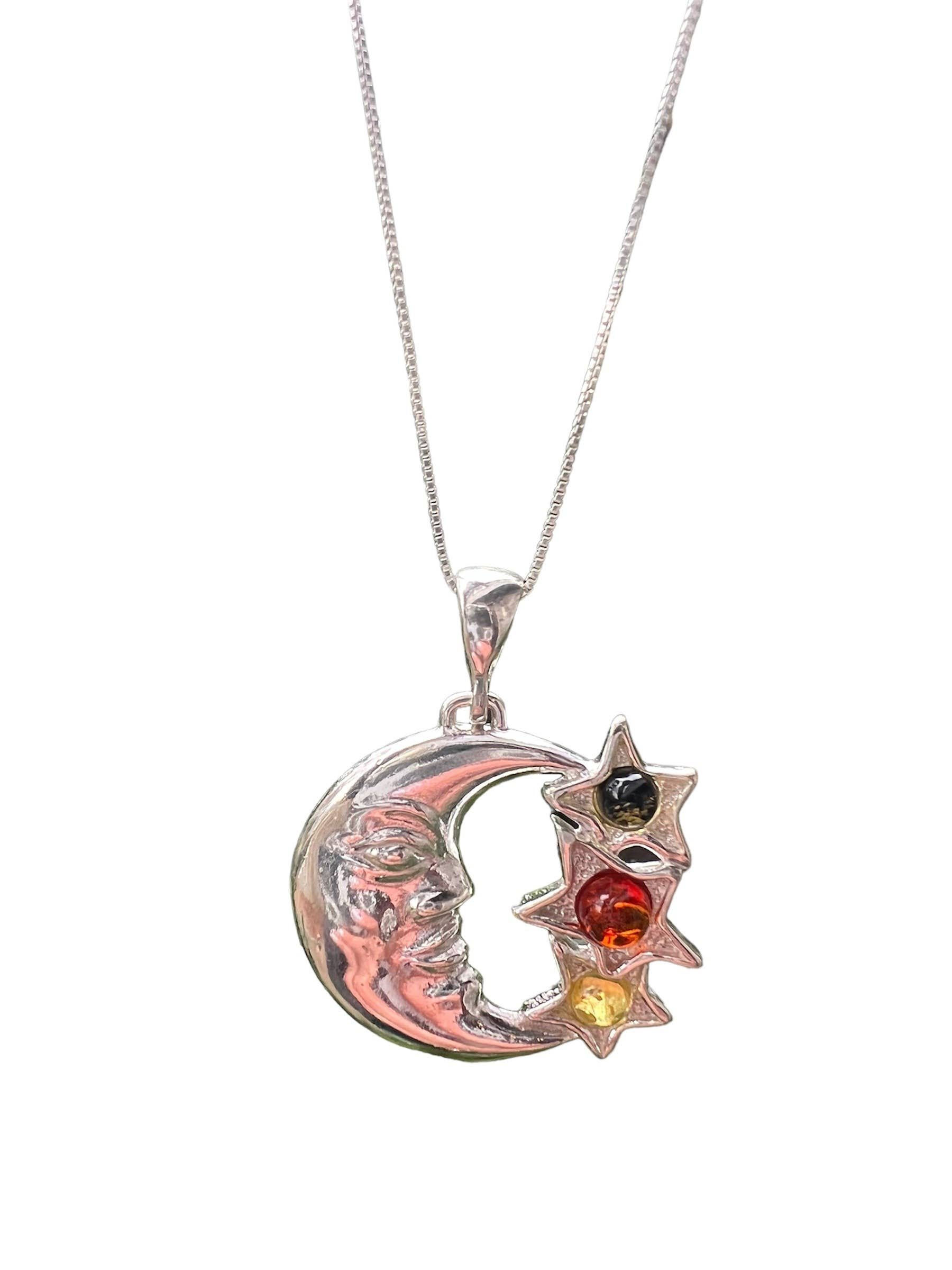 Silver necklace with crescent moon and star pendant, gemstones on white background.