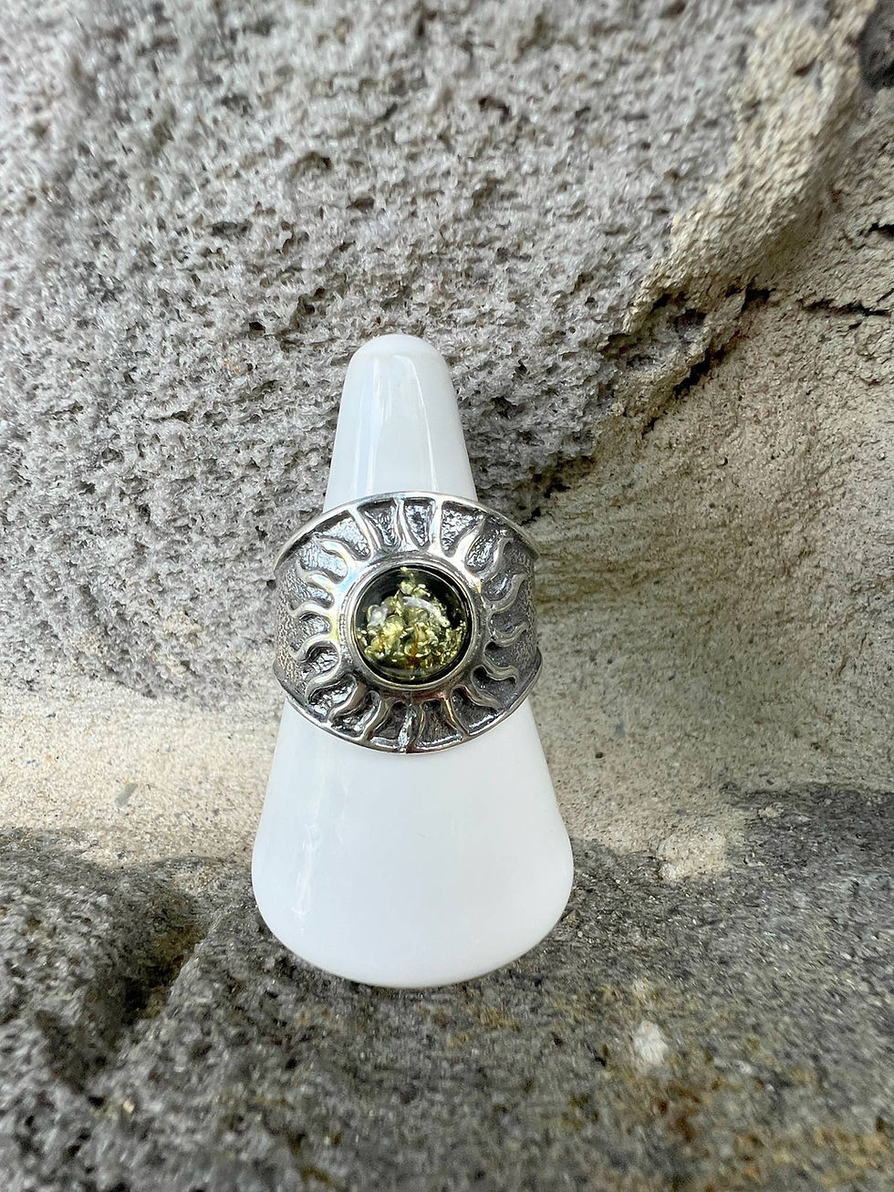 Thumbnail: Silver ring with sun design and green center stone on display, neutral background.