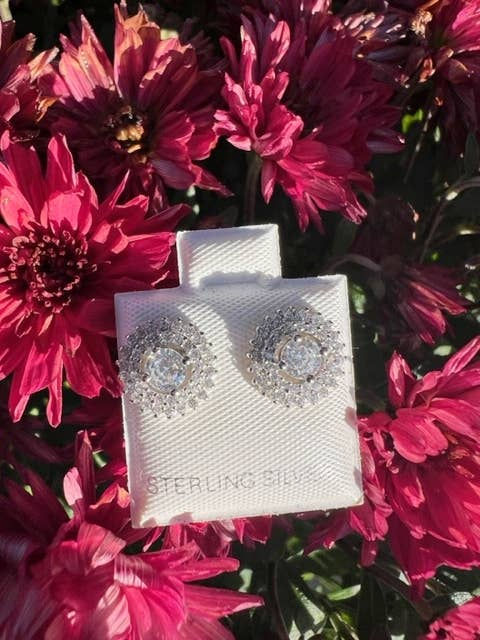 Pair of sterling silver earrings with flower-like design on display