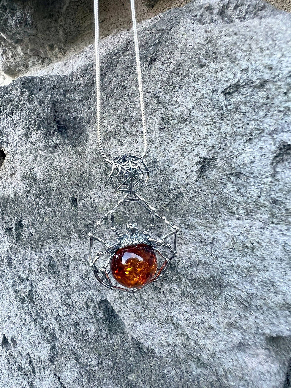 Thumbnail: Amber pendant necklace hangs on gray rock background, beautiful jewelry displayed outdoors