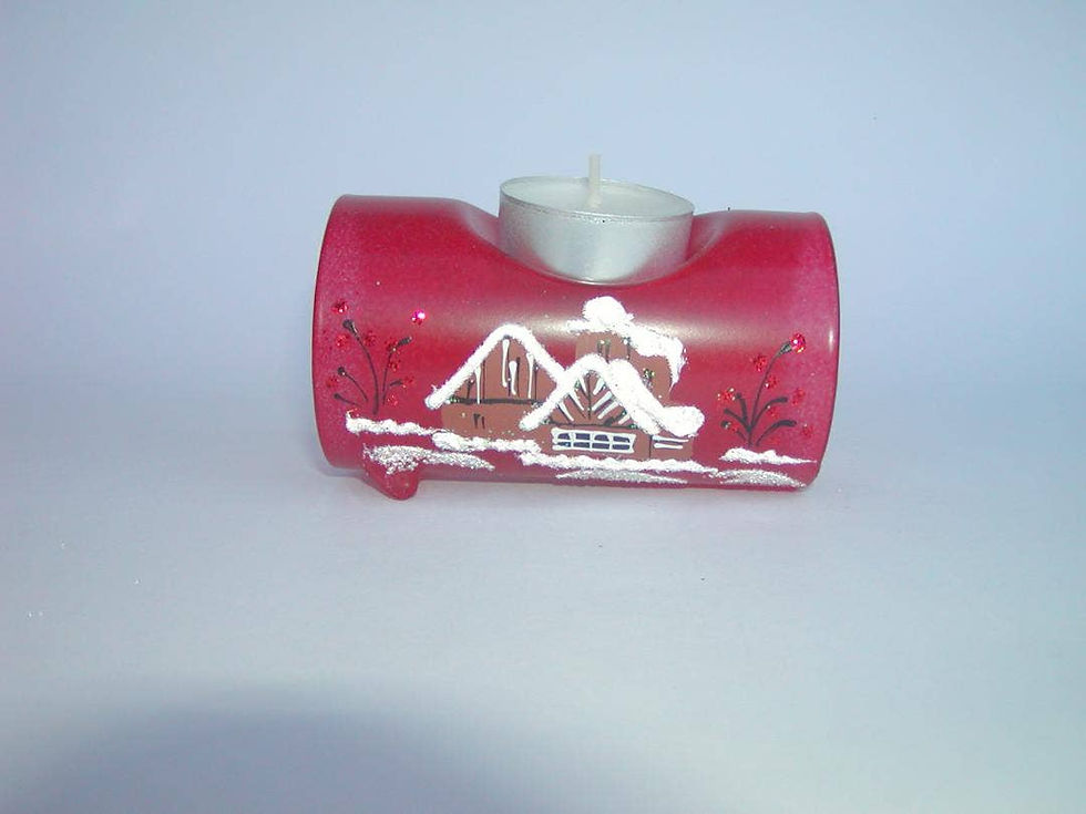 Red candle holder with winter scene and a lit tea light candle.