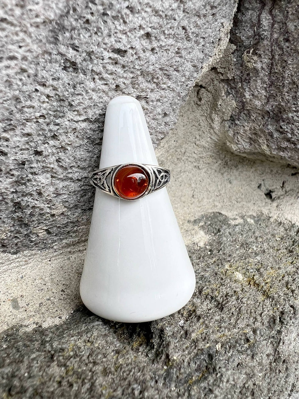 Thumbnail: Silver ring with a red gemstone on a white display holder.