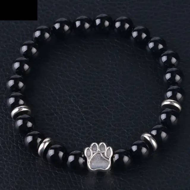 Thumbnail: Black beaded bracelet with a paw charm on a dark background.