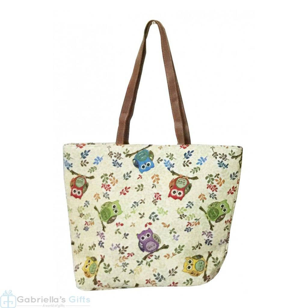Owl-patterned tote bag with brown straps and colorful owl design on display.
