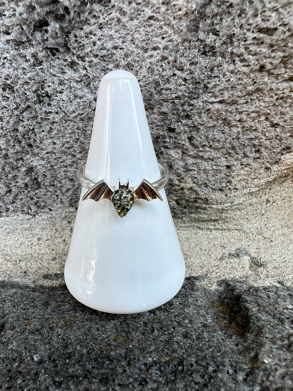 Thumbnail: Bat ring on white stand against stone wall background, spooky jewelry