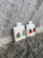 Thumbnail: Two pairs of earrings on white stands against a rough, gray background.