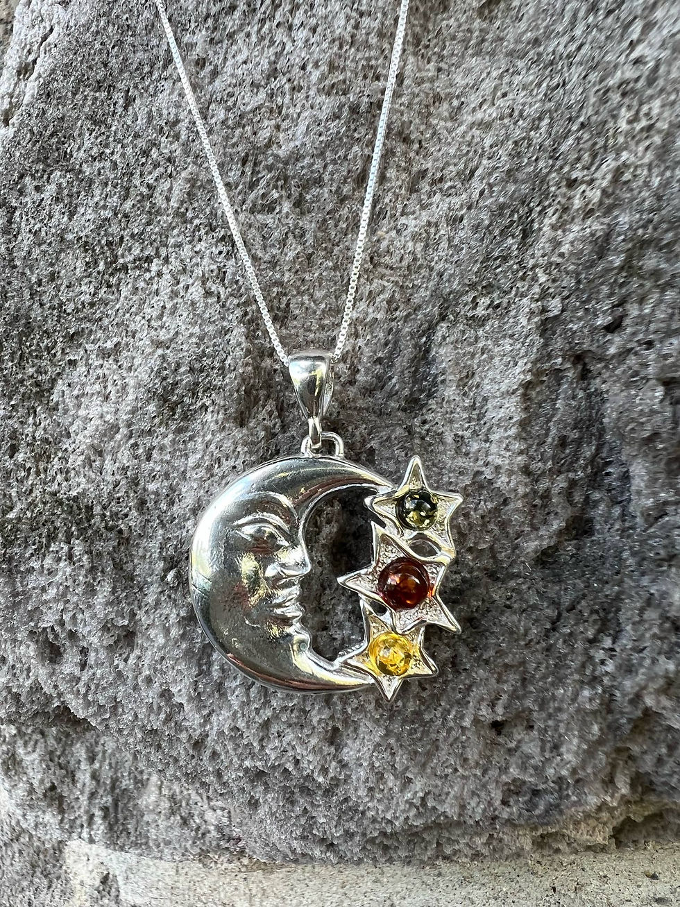 Thumbnail: Silver moon pendant necklace with stars set against a stone background
