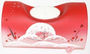 Red candle holder with a white candle, floral design, and scenic view.
