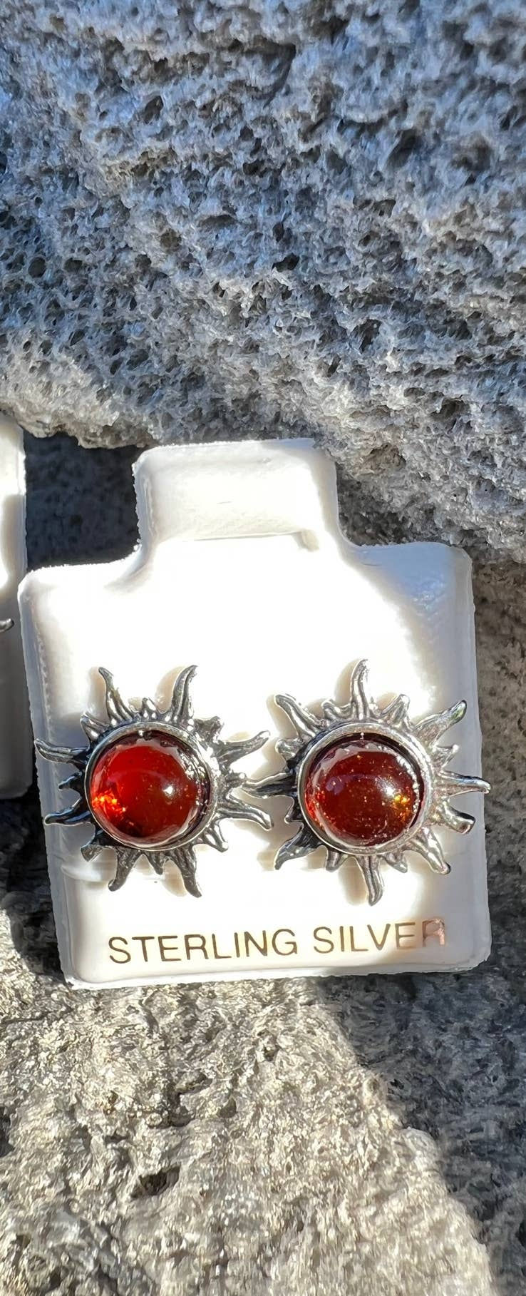 Thumbnail: Red gem earrings with STERLING SILVER text, displayed on a white stand, sunburst design.