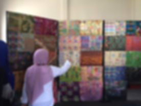 A broker is showing the handmade songket in her house.