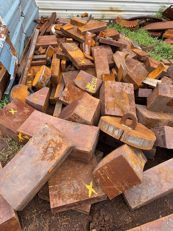A neat stack of reddish-brown rectangular objects, possibly bricks or wood.