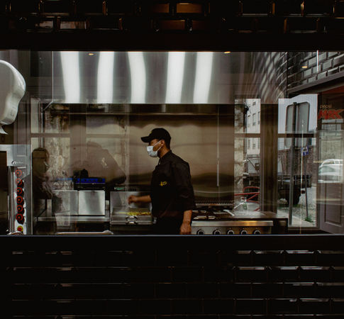 Chef working in a modern, stainless steel kitchen, emphasizing the professional and clean environment, photographed by Nadya Costa Fotografia.
