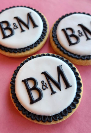 Three round custom cookies with black and white B&M icing.