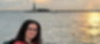 Jessica smiling in NYC with the Statue of Liberty behind her