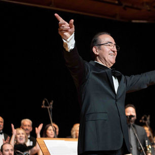 A conductor acknowledging the audience during a celebratory award moment.