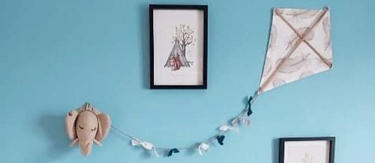 cerf volant en tissu accroché au mur bleu