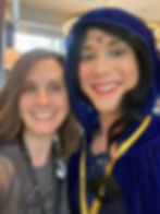 Selfie of me (woman with light brown hair and a gray tshirt) and Recappa dressed as Moiraine at JordanCon 2021.