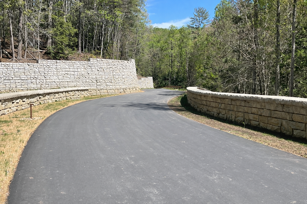 Redi-Rock precast concrete retaining wall along a paved road.