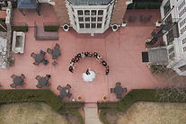 Aerial drone photo of Pine Knob Mansion patio, couple surrounded by bridal party