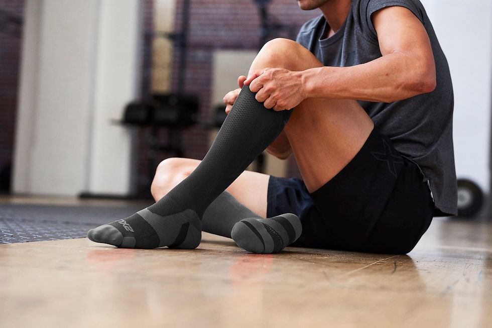 Man posing in 2XU's Vectr Cushion Full Length Socks on gym floor