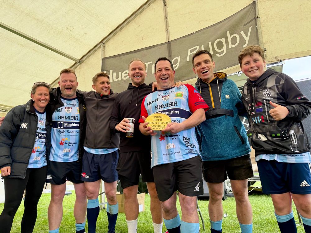 Tournament winners holding a trophy in MiraVeta-sponsored shirts