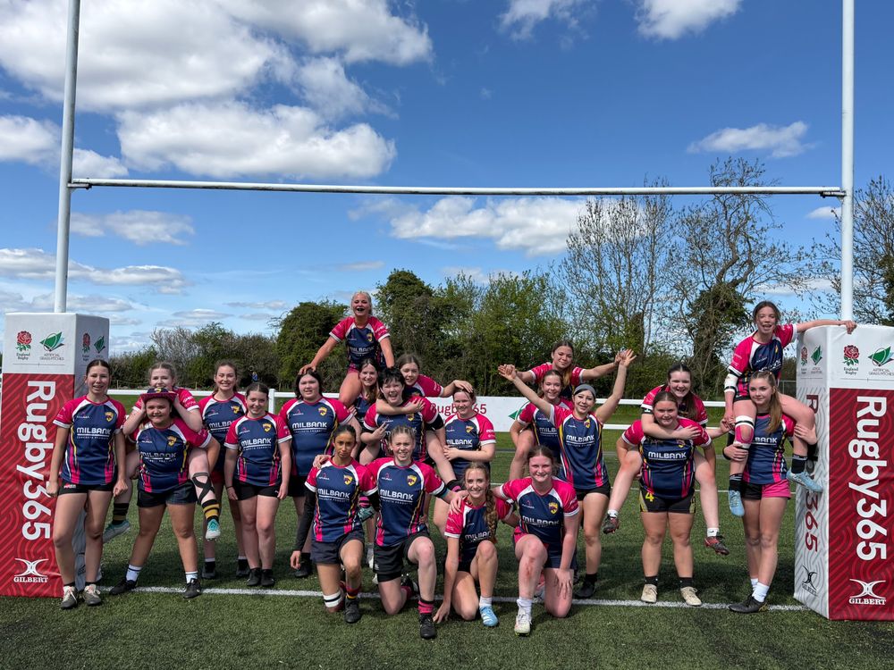 Girls' rugby squad celebrating under the posts