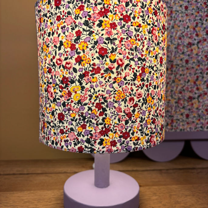 Small lilac table lamp with matching fabric noticeboard in background