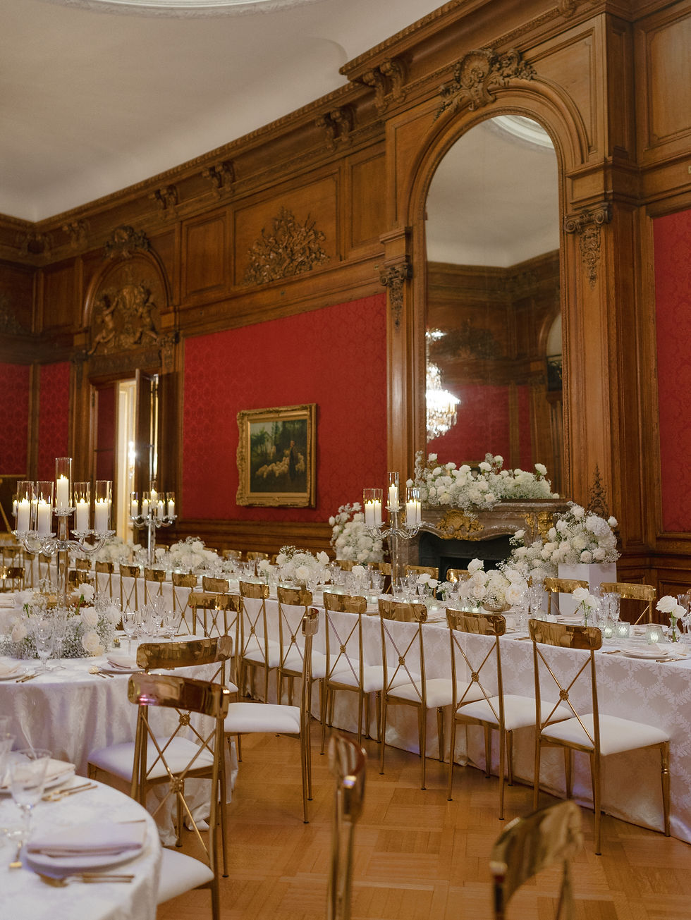 White floral arrangements and baby’s breath framing the grand fireplace for the head table.