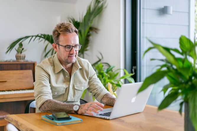 Businessman working on a laptop in a relaxed home office setting