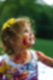 Small girl smiling with pain on her face and clothes