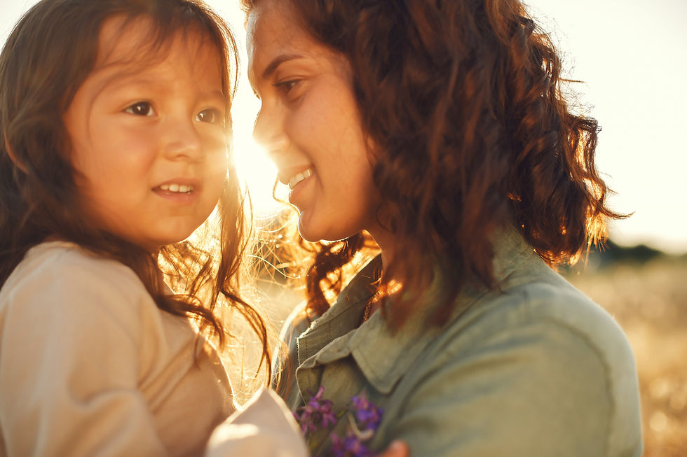 Mother holding child in her arms outdoors