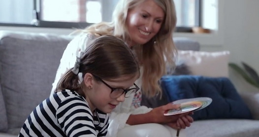 Dr Maxine and a young child looking at the wellbeing cards