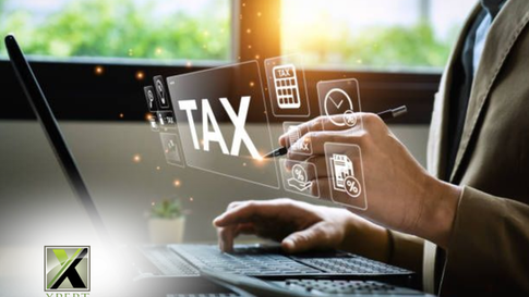 The image shows a person using a laptop with a digital interface displaying various tax-related icons such as a calculator, tax documents, and percentage symbols. The person is holding a pen, and the scene is illuminated by natural light from a window. The Xpert Business & Tax Solutions logo is visible in the lower left corner.