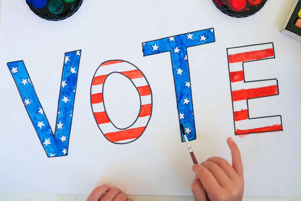 A child's hand painting a picture saying "vote."