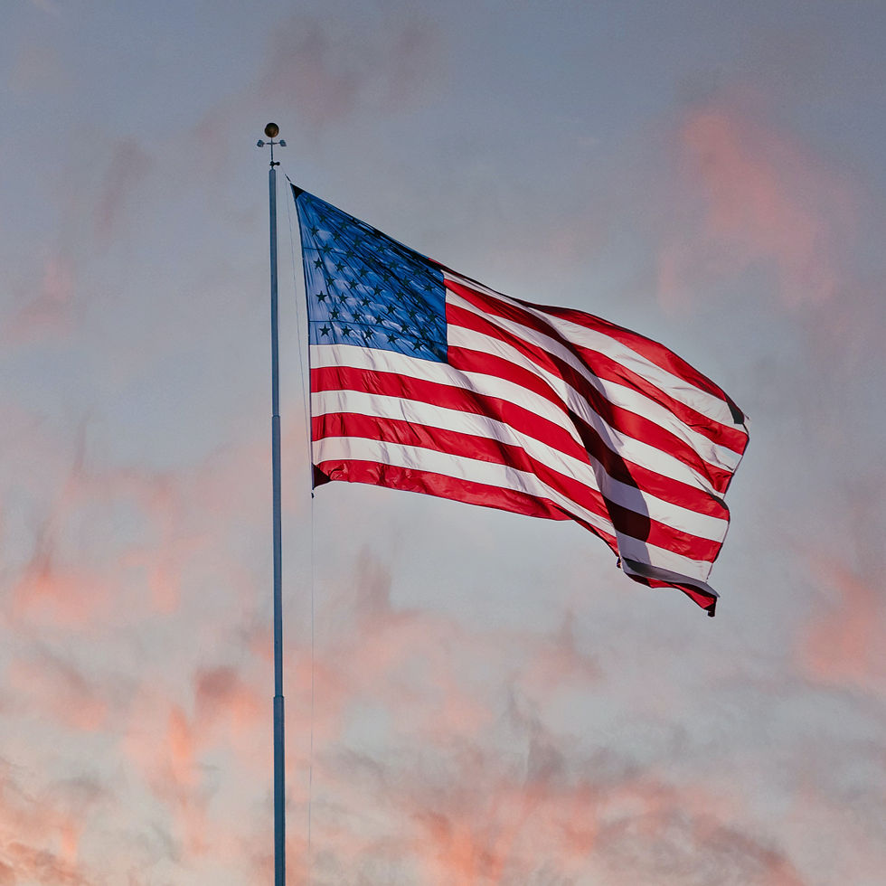 The American Flag in front of a sunset.