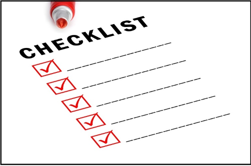 Red marker atop a paper labeled "CHECKLIST" with five red-checked boxes against a white background. Clean, organized, methodical mood.