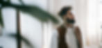 Black man standing in his living room and thinking