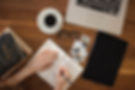 woman journaling on her desk with a cup of coffee