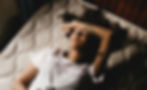 woman laying on bed cramping