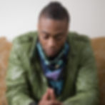 African American man in green jacket looking concerned