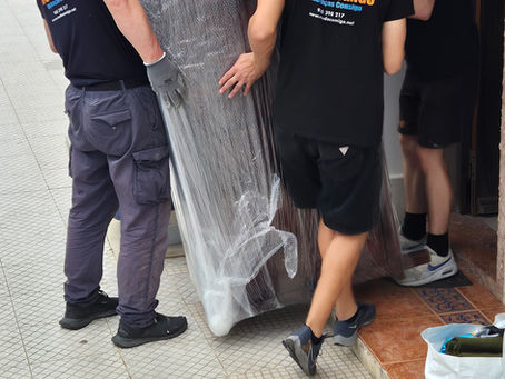 Equipa Mudacomigo a transportar móveis protegidos durante uma mudança urgente em Lisboa