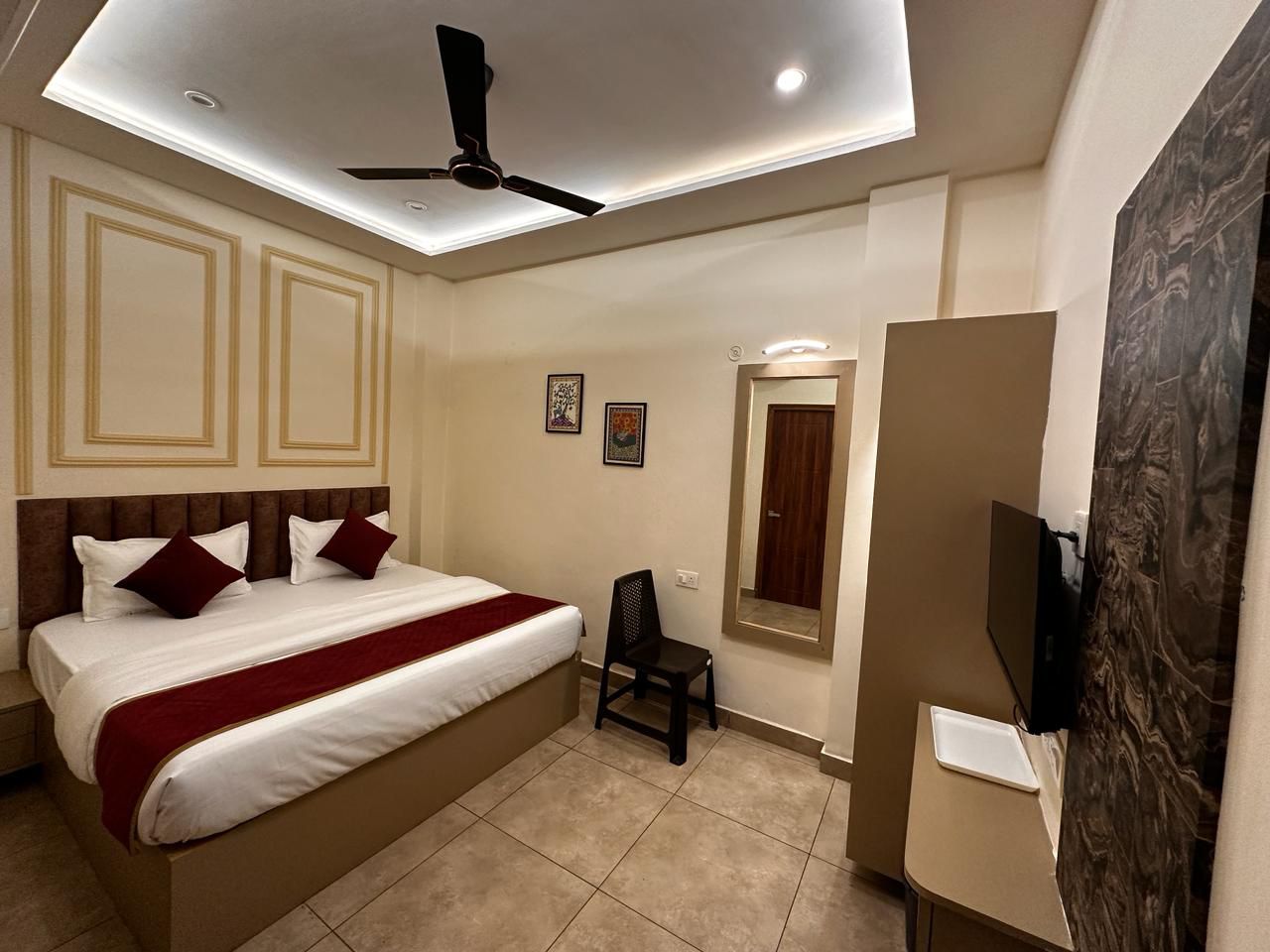 Elegantly designed bedroom featuring a plush king size bed with white and red bedding, complemented by decorative wall panels