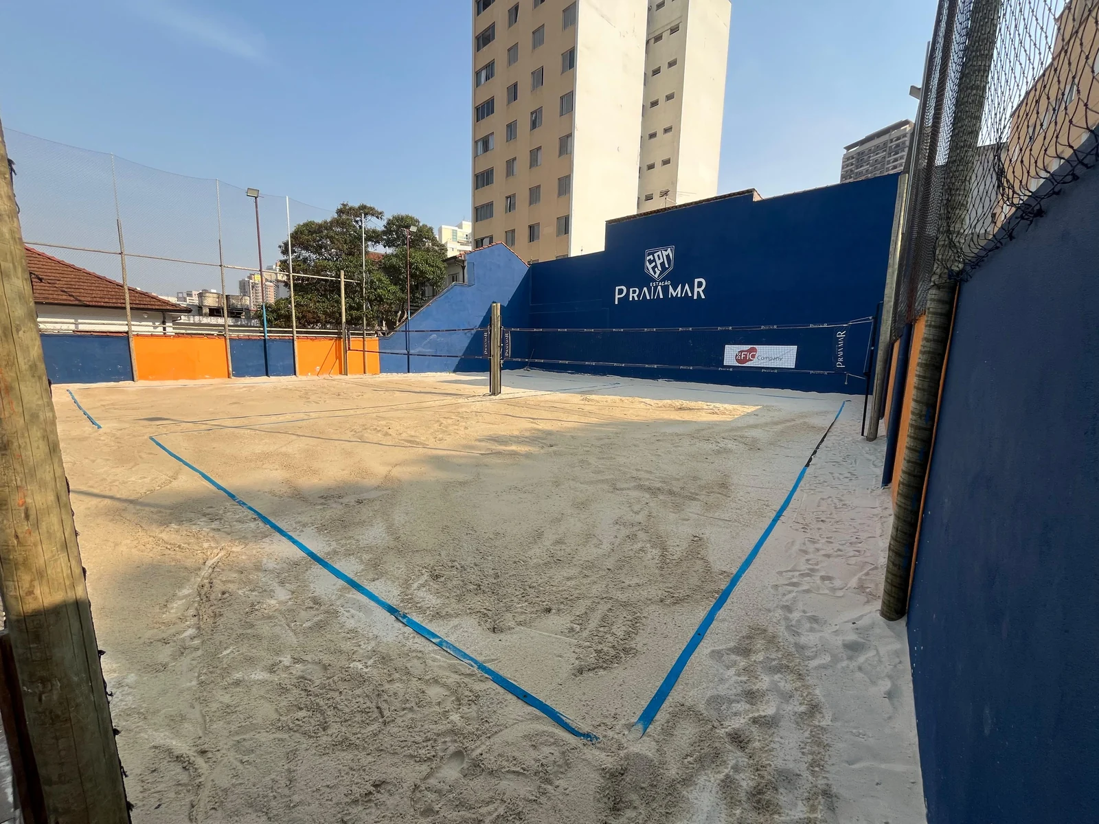 Fotografia real das quadras de areia da Estação Praia Mar, com linhas de jogo e rede.