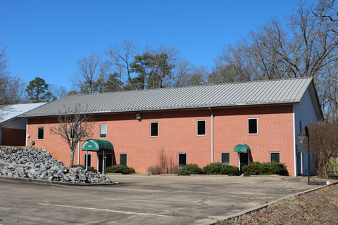 Two-story church building with brick exterior and metal roof