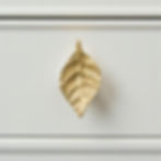 Thumbnail: Solid brass leaf cabinet and drawer knob with detailed veining and warm gold finish, mounted on a white drawer
