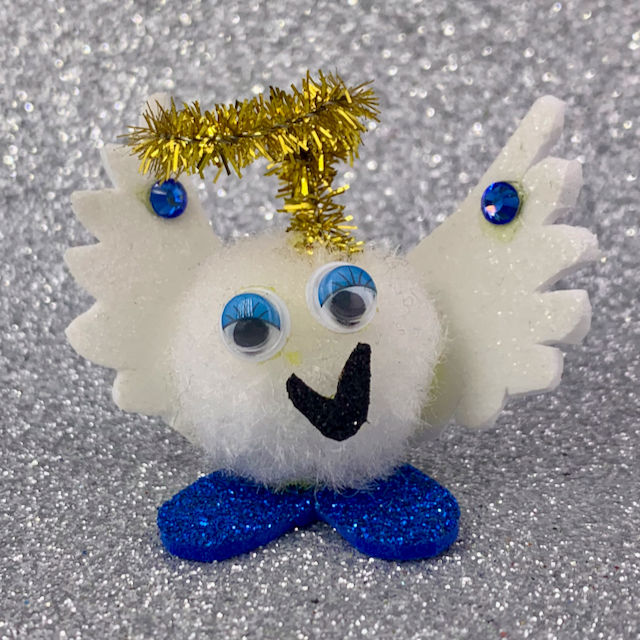A white cotton pom pom with googly eyes and a metallic gold pipe cleaner angel halo