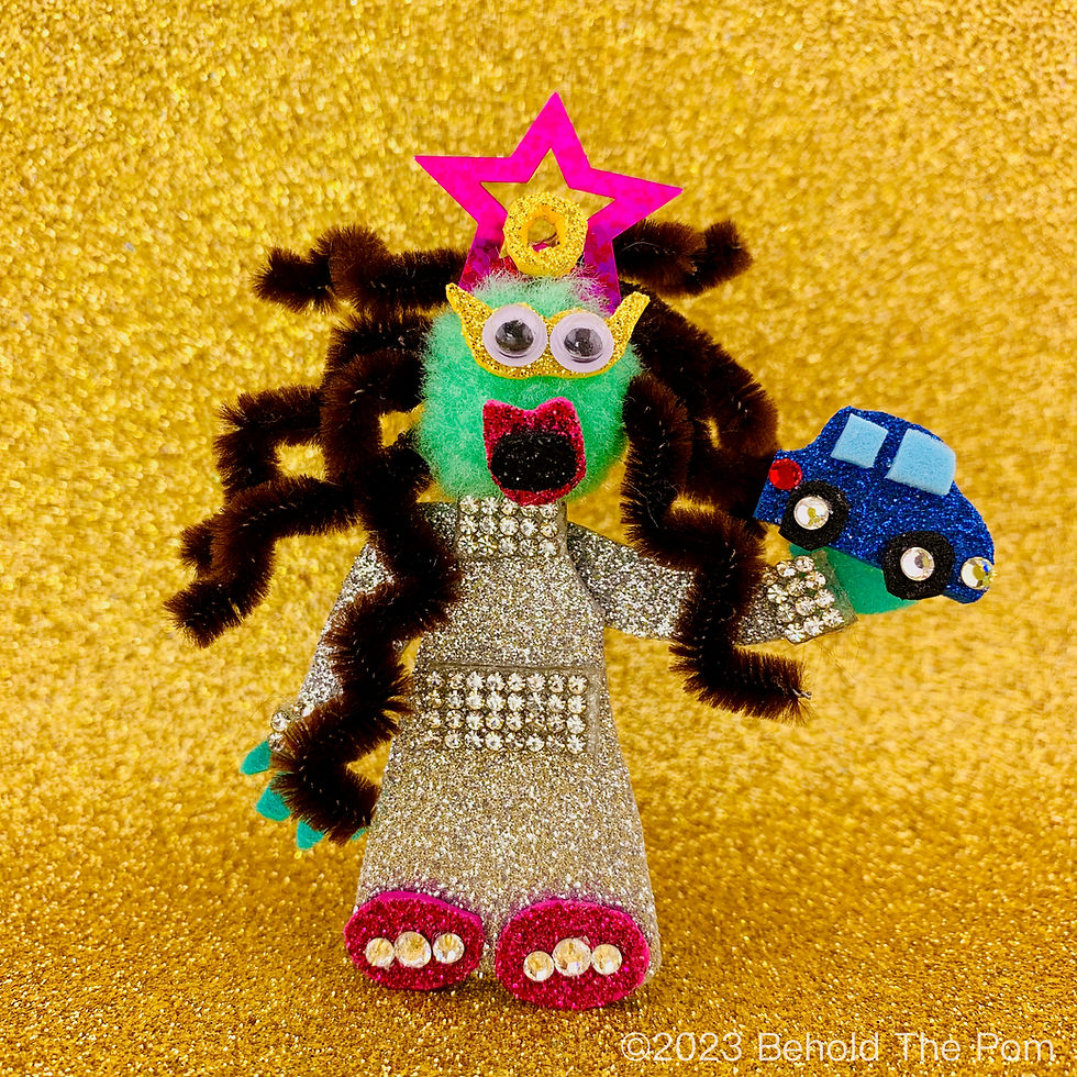 Green cotton pom pom character with googly eyes poses in front of a gold glitter background